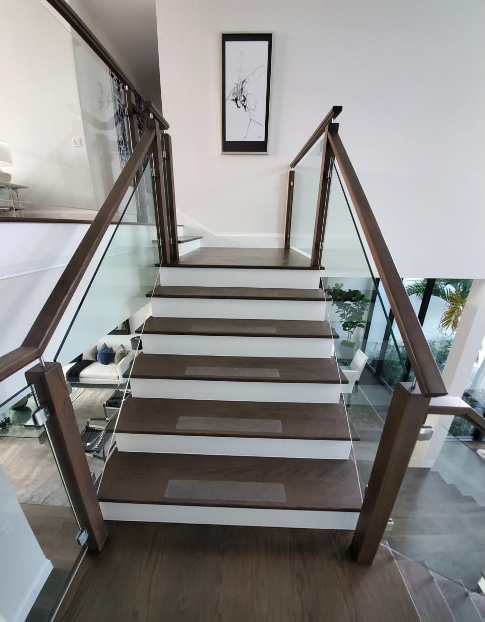 Staircase with glass railing and wood posts