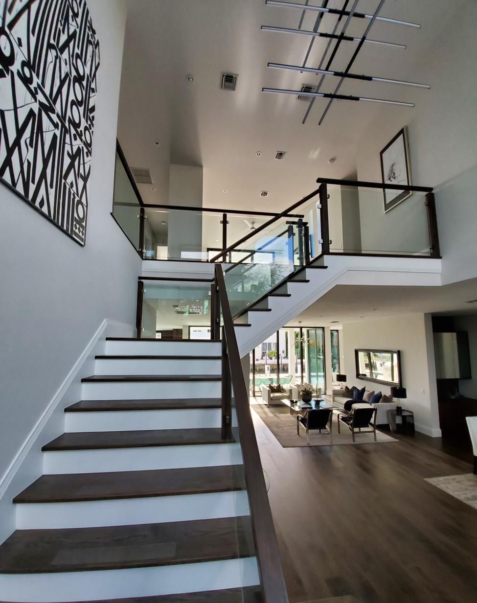 Glass-railed staircase in a two-story foyer