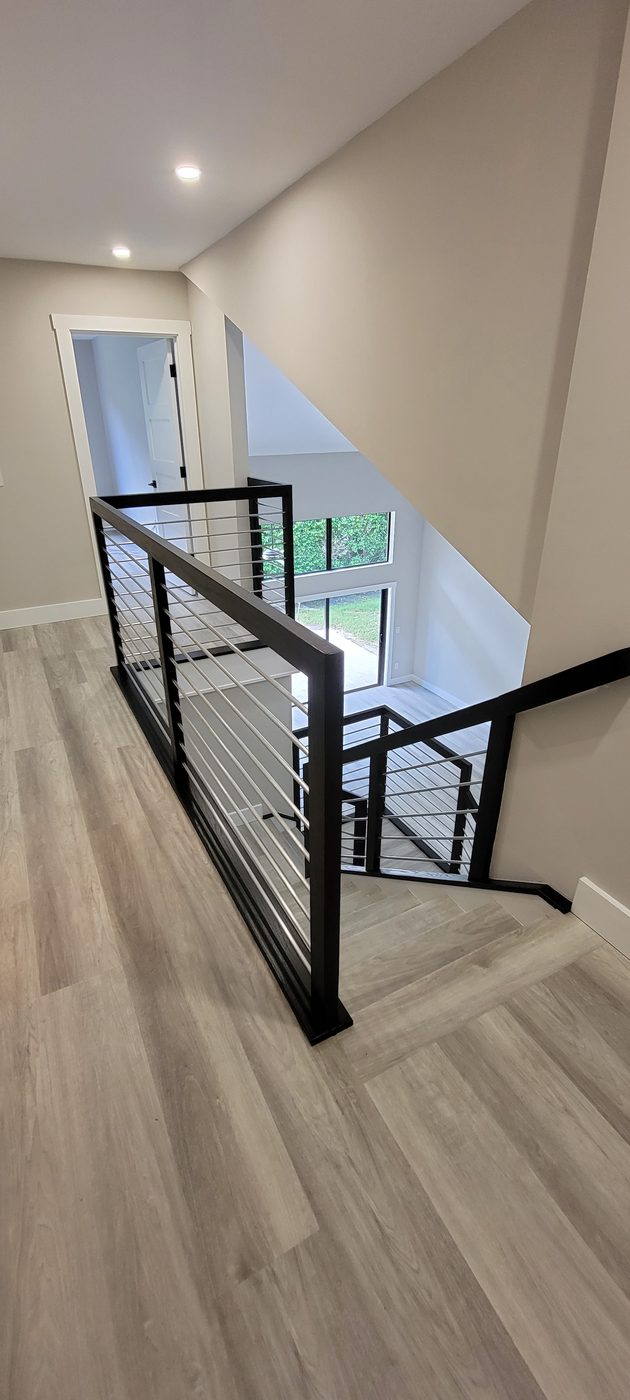 Landing railing with stainless rods and dark wood frame