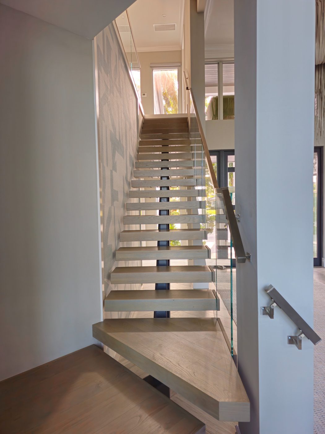 Glass-railed landing above a floating staircase