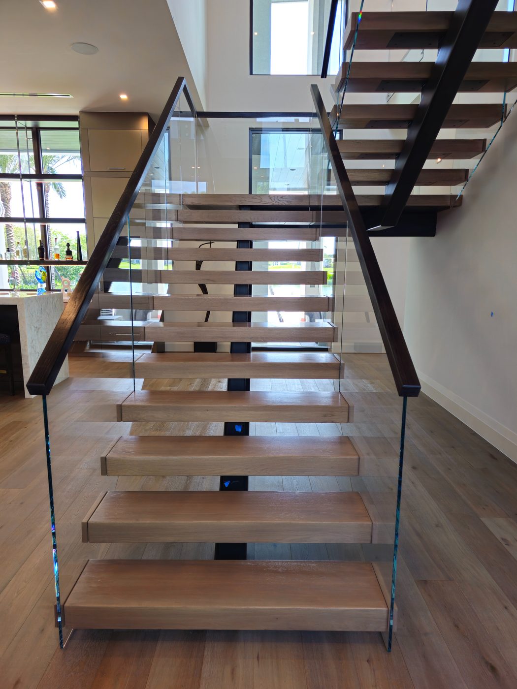 Floating staircase with frameless glass and wood handrail