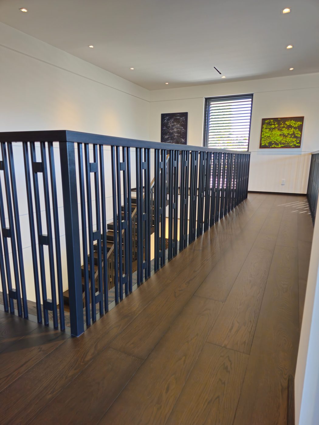 Floating dark-wood staircase with metal rod railing