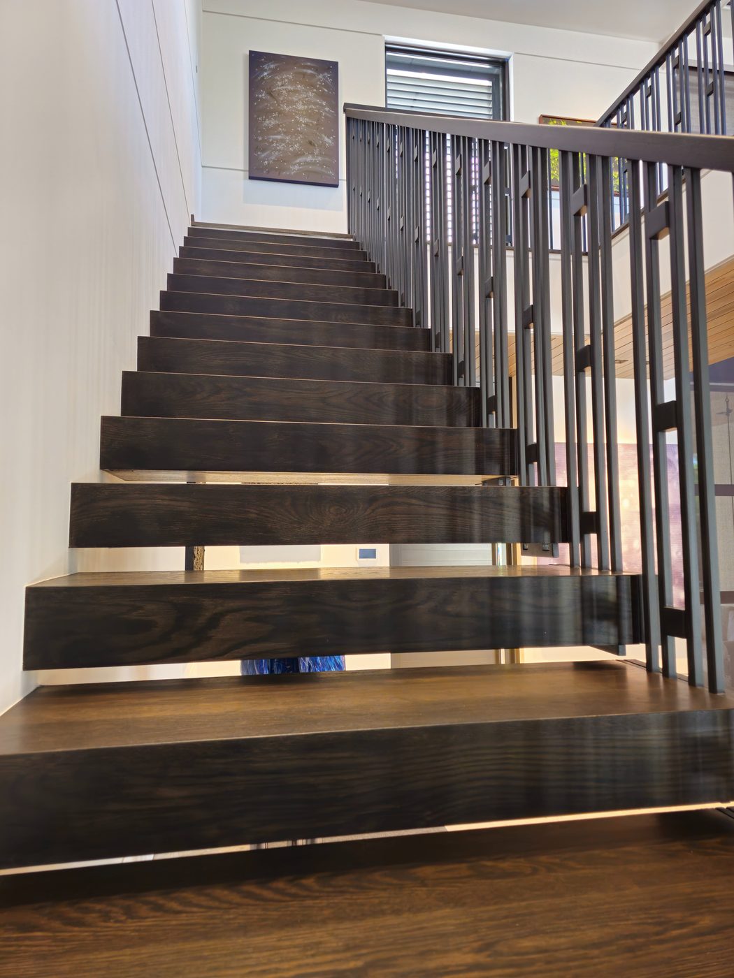 Dark wood floating treads with rod railing