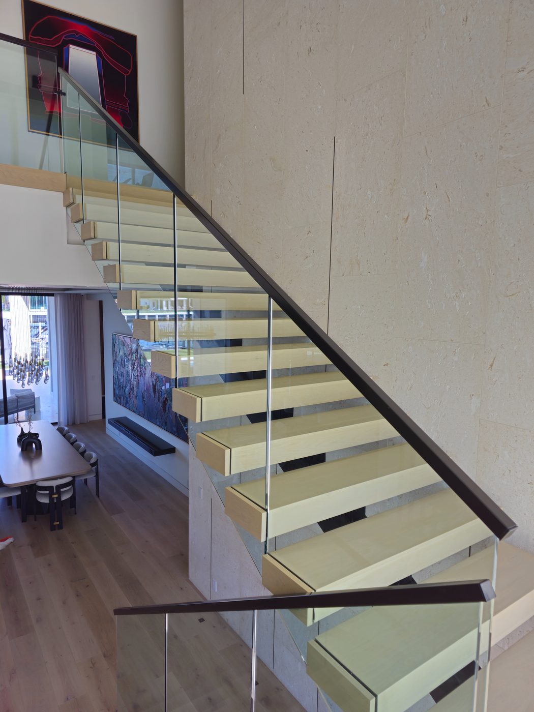 Glass-railed mezzanine above a floating staircase