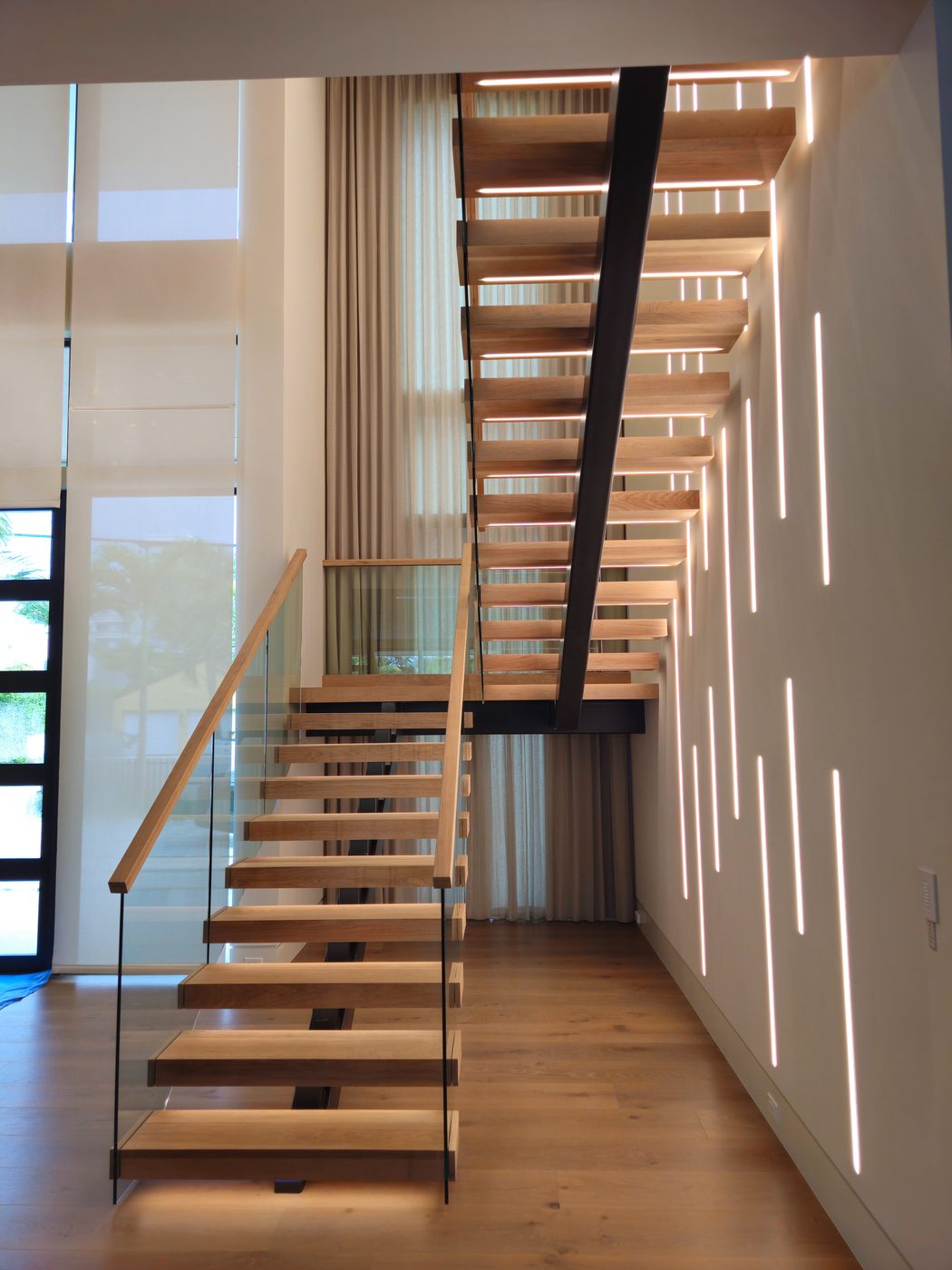 Floating staircase with a backlit feature wall