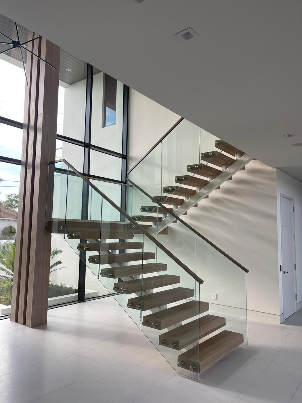 Floating staircase between wood feature columns