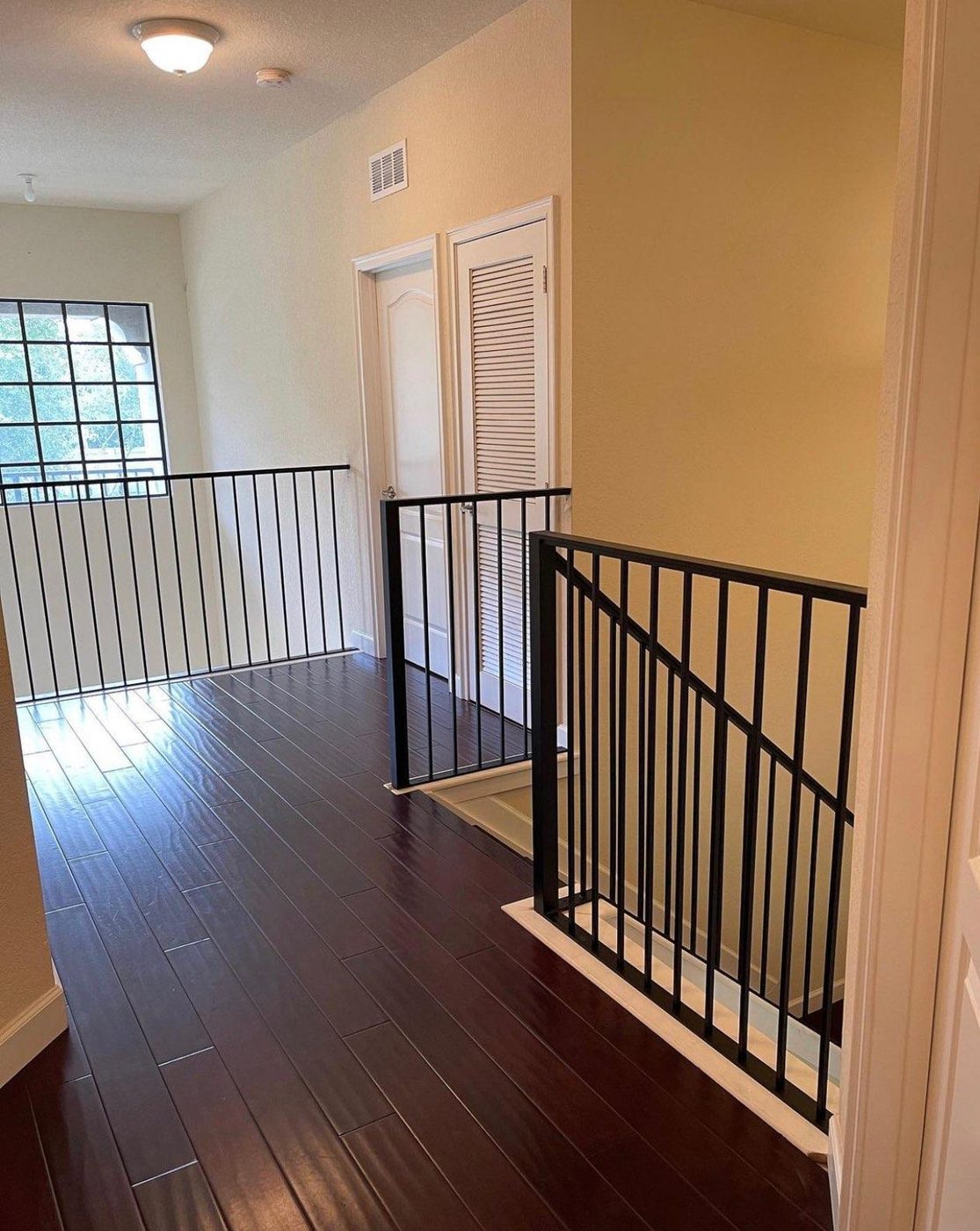 Black iron picket railings on an upstairs landing