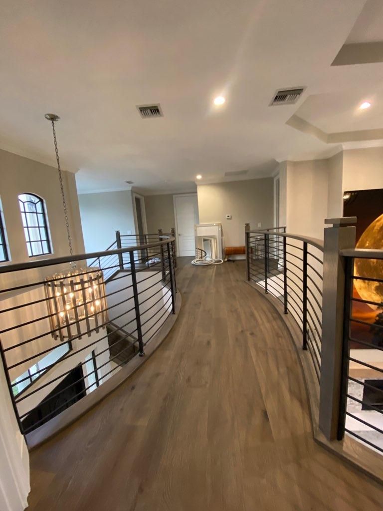 Curved horizontal-rod railings along an upstairs hall
